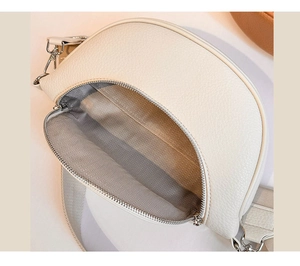 Top view of cream crossbody bag featuring pebbled leather texture and herringbone lining