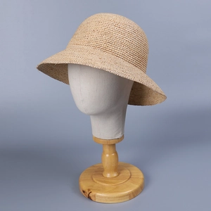 Chapeau cloche minimaliste en paille de raphia beige sur un support d'exposition