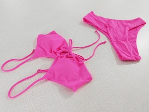 Detailed view of rose pink halter bikini set with ring hardware and high cut bottoms