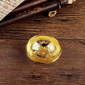 Detailansicht einer goldenen Minischale mit geprägten Kois und Glücksschriftzug