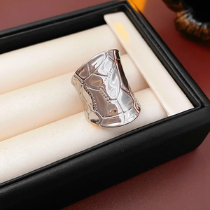 Vue détaillée d'une large bague géométrique argentée avec une texture martelée