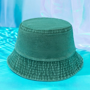 Close-up of dark green washed denim bucket hat with reinforced stitching on a blue water surface