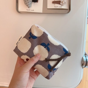 Detail of grey floral cotton linen coin purse with simple wish label and braided zipper pull
