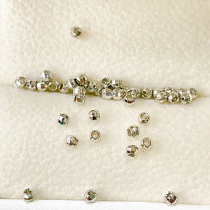 Detailed view of faceted silver-plated metal spacer beads for DIY jewelry making