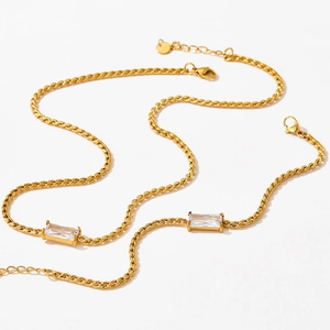 Minimalist gold necklace featuring a rectangular clear gemstone on a high-polish chain