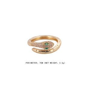 Gold snake ring with sparkling zircons and green crystal eyes on a clean white background