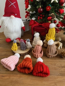 Detailed view of mini knitted Christmas hats in various colors for festive crafts