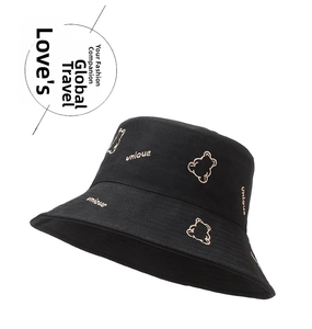Close-up of black cotton bucket hat featuring embroidered bear and unique lettering