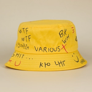 Detailed view of yellow bucket hat with hand-drawn graffiti and letter prints