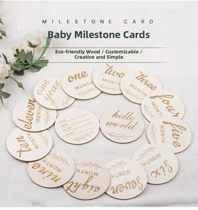 Vue à plat de 14 cartes de naissance en bois rondes avec chiffres et fleurs gravés