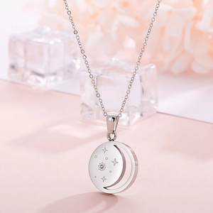 Macro shot of silver crescent moon and star necklace with a sparkling small gemstone