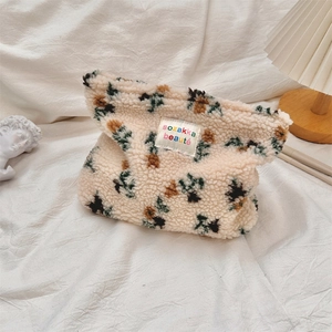 Detail of plush beige cosmetic bag with tree patterns and sozakka beauté label