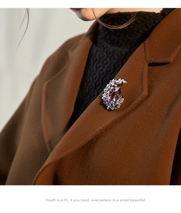 Macro shot of an elegant lavender moon brooch with crystals on a caramel wool coat