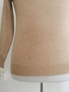 Detailaufnahme des khakifarbenen Strickpullovers mit Rippensaum und feiner Stoffstruktur