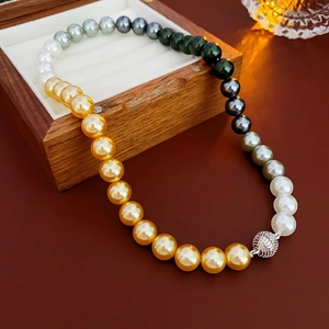 Detail of gradient pearl necklace with sparkling diamond ball clasp on a wooden box