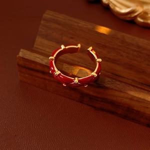 Macro shot of gold plated wave ring with red enamel and small gold bead details