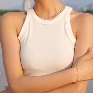 Conjunto de collar y pulsera de margaritas en oro de 18 quilates usado por modelo