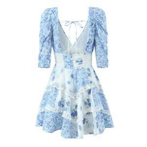 Back view of blue floral dress with deep V-neck, lace panels and tiered skirt details