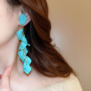 Detail showing long turquoise petal tassel earrings with elegant golden chain hangings