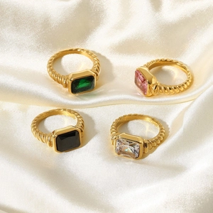 Flat lay of vintage gold twisted croissant rings with colorful rectangular zircon stones