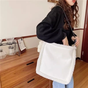 Detail of white leather shoulder bag with plush shearling trim and slim black straps