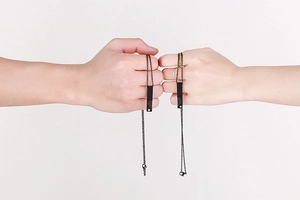 Colliers assortis pour couples avec pendentifs noirs portés par un homme et une femme