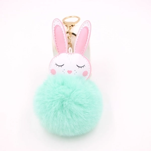 Dettaglio di un portachiavi a forma di coniglio bianco morbido con pompon verde menta
