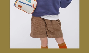 Detail view of children's brown corduroy shorts on a model with high texture clarity