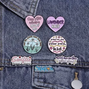 Set of 7 colorful enamel pins with inspirational lyrics on blue denim jacket