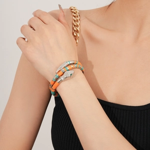 Macro detail of a colorful beaded snake wrap bracelet on a female wrist in professional lighting