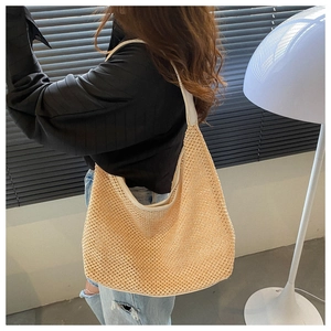 Detail of beige woven hobo bag showing hollow mesh texture and wide shoulder strap
