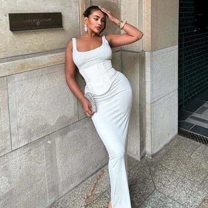 Detail view of a white two-piece set with a lace-up corset top and long slim maxi skirt