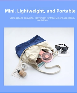 Pink handheld mini fan placed in a canvas bag for portable travel use and storage