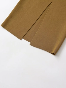 Détail de l'ourlet de la jupe en maille moutarde montrant la fente et la texture