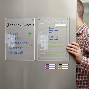 Detailed view of clear acrylic magnetic weekly planner and grocery list on a fridge