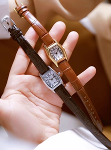 Close-up of rectangular quartz watches with leather straps and Roman numeral dials