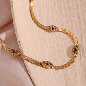 Detail of 18K gold plated devil eye necklace with sparkling diamonds and snake chain