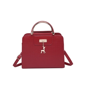 Sac à main rouge foncé à motif crocodile avec poignée dorée et pendentif cerf