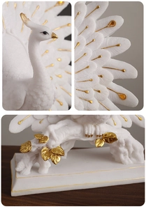 Macro details of white and gold peacock statue showing texture and intricate base