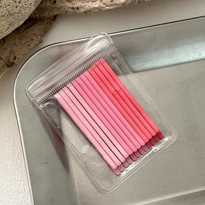 Close-up of matte pink gradient metal hair pins organized in a transparent PVC bag