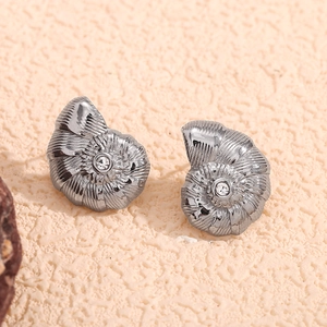 Vue détaillée de boucles d'oreilles conque argentées avec des cristaux étincelants