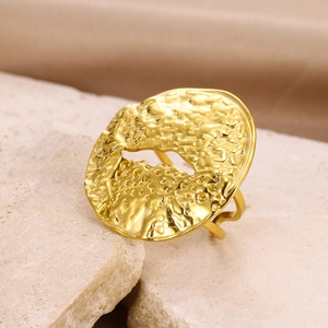 Detailed close-up of a gold geometric ring featuring a hammered texture and cutout center