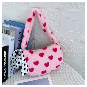 Detail of pink faux fur heart pattern bag with elegant polka dot ribbon bow decoration