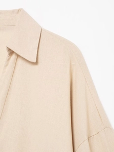 Détail d'un col de chemise en lin beige et épaule tombante avec texture tissée
