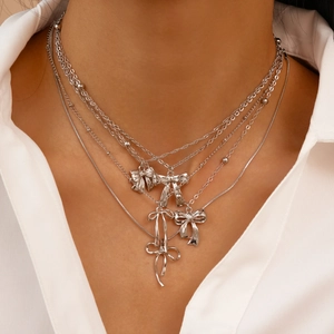 Gros plan d'un collier multicouche argenté avec des nœuds en métal 3D sur un mannequin