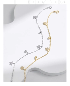 Dettaglio di bracciali in argento s925 e oro con stelle scintillanti e perle lucide