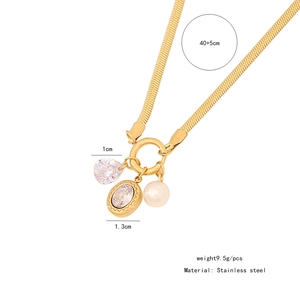 Macro detail of gold stainless steel necklace with teardrop zircon and white pearl pendant