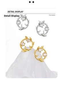 Detail of silver and gold wreath stud earrings with glittering zircon stones