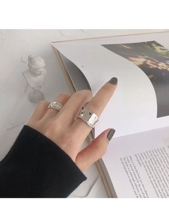 Close-up of minimalist S925 silver rings with irregular texture and engraved letter detail