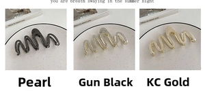 Detailed views of three wave-shaped hair claws in gunmetal diamond, KC gold, and pearl